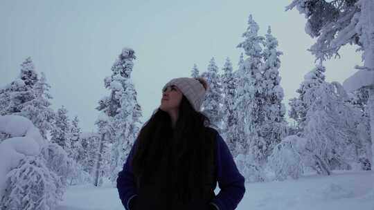 女孩在芬兰北极圈拉普兰的雪林中探索美丽的
