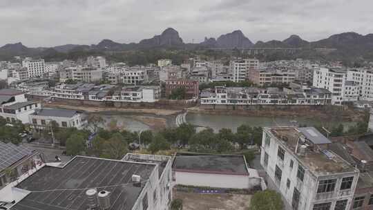 航拍河流上的石墩路到群山环抱的城镇大景