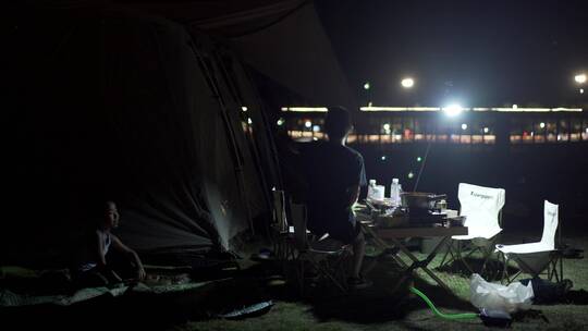 帐篷旁正在露营吃晚餐的小朋友