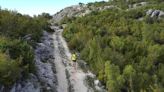 跑步者在高山的山路上快速奔跑，在美丽的风