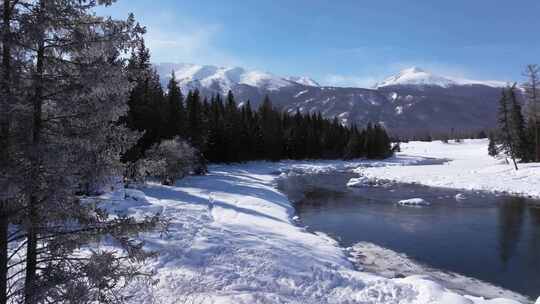 航拍新疆冬季喀纳斯河流晨雾雪山森林雪景