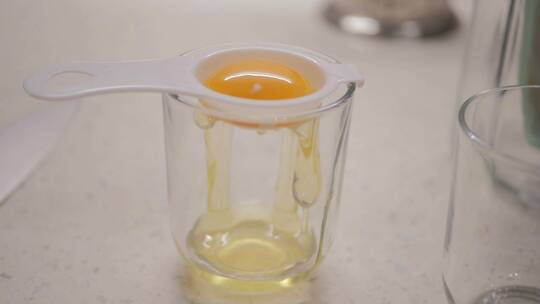 厨师把蛋黄放在分蛋器里