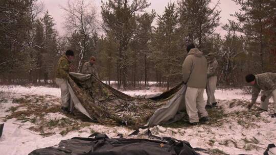 一群男人在雪地里搭帐篷