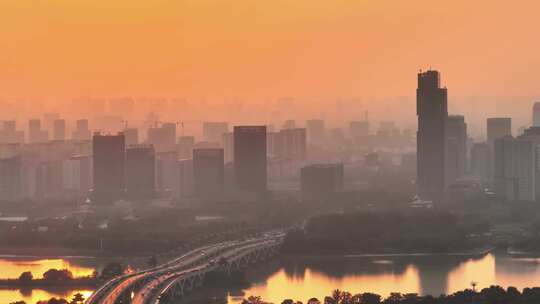 航拍夕阳高铁行驶桥梁河流车流建筑群高楼