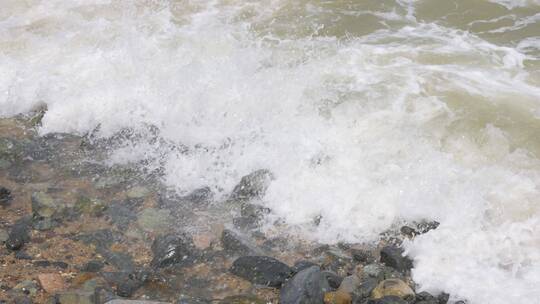 实拍浪花拍打在海边的礁石上