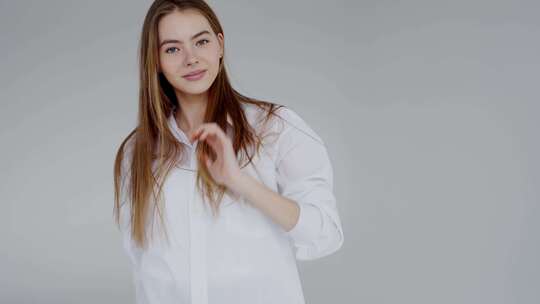 自信的年轻女子穿着白色衬衫微笑着摆姿势