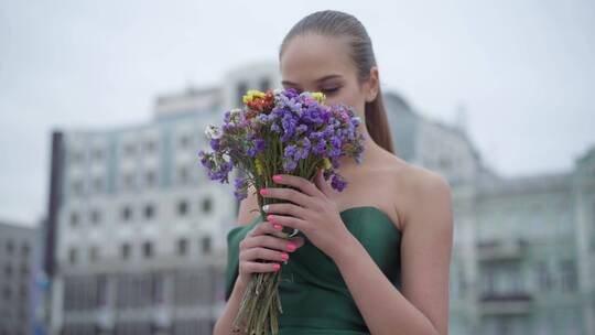 女孩站在街道手捧野花