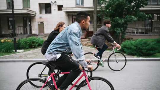 年轻人一起沿着城市街道骑自行车