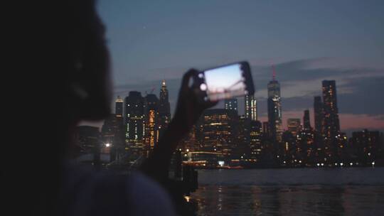 女人用智能手机拍摄夜景视频素材模板下载