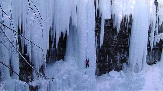男人爬上冰冻瀑布视频素材模板下载