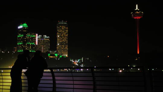 情侣靠在围栏上欣赏城市夜景