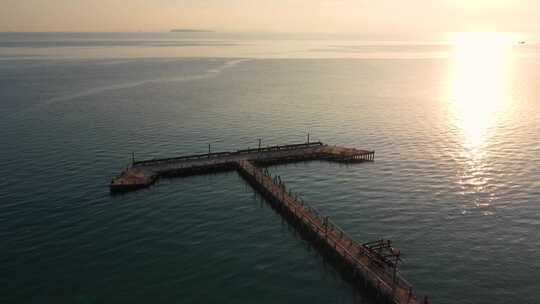 日落时平静的海洋与混凝土码头的全景，柬埔