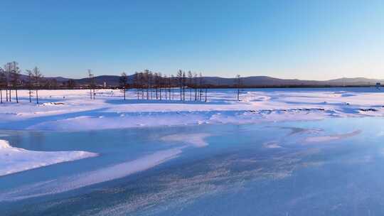 夕阳下内蒙古北方不冻河平静水面雪雾袅袅