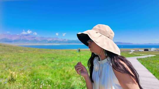女子草原手持花草眺望远方