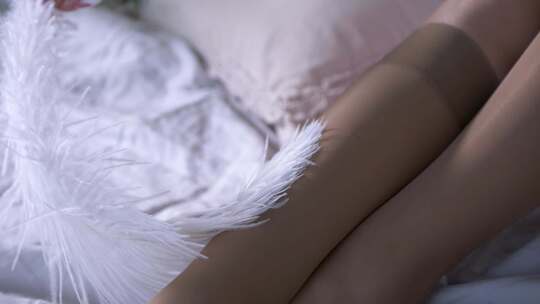 白色羽毛轻轻触摸女人的腿在紧光滑慢动作敏视频素材模板下载