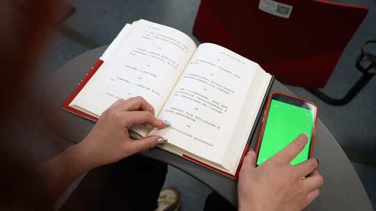 一个女孩在阶梯教室看书看绿幕手机