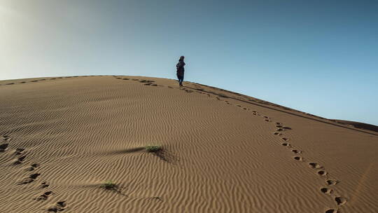 男人独自走在沙漠里