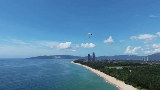 航拍蓝天白云动力伞三亚海棠湾海岸线飞行