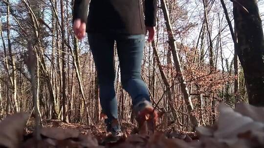 在树林里踢踏这枯叶的女人视频素材模板下载