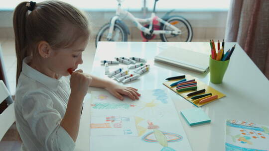 小女孩在桌子上画画