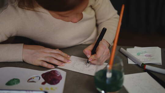 特写镜头一个女人坐在桌子旁用记号笔画了一