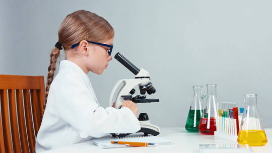 女孩用显微镜观察实验视频素材模板下载