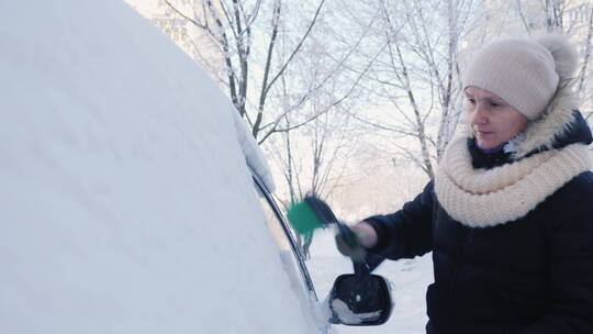 女人在除车上的雪