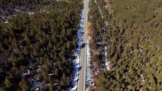 航拍雪山森林公路车辆行驶