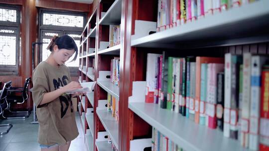青年女性女生在图书馆看书学习阅读讨论