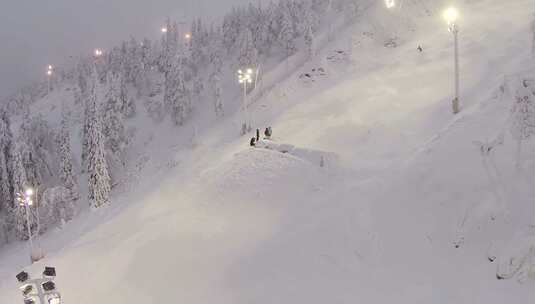 人们在斜坡上看着一个人在空中滑雪