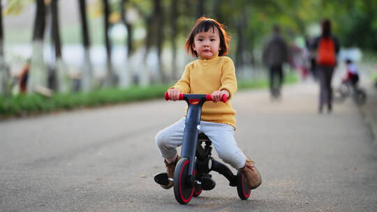 小女孩在公园里骑车玩耍慢镜头视频素材模板下载
