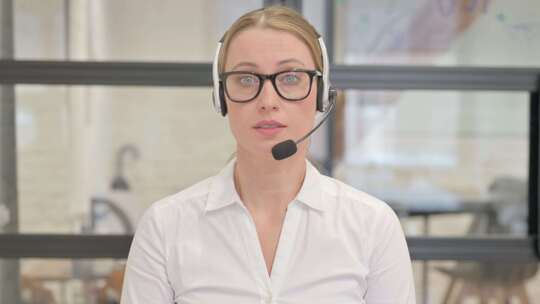 带耳机的成熟女人与客户交谈