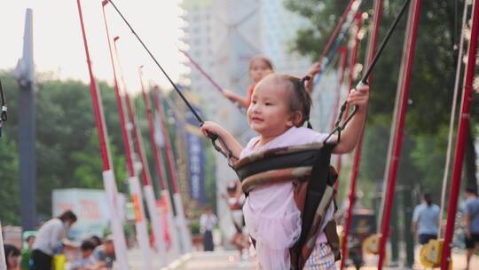 可爱小孩夏天城市广场玩耍蹦床秋千