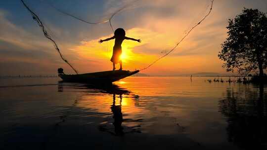 夕阳下湖面渔船与渔夫剪影