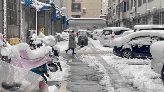 小区楼房停车积雪结冰出行的人