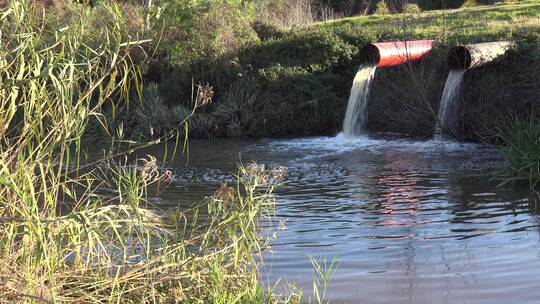 工业污水通过工业管道排到小溪里