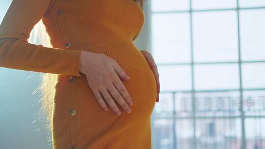 怀孕孕期人们期待未来孕妇手触摸大肚子靠近