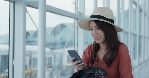 妇女在机场使用手机