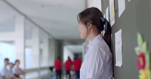 一个穿着白色制服的快乐微笑的亚洲高中生女
