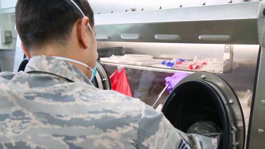 美国陆军医生和护士在移动分析实验室系统内进行冠状病毒检测
