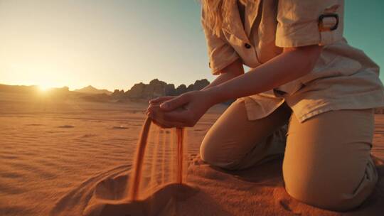 在沙漠里玩沙子的女人