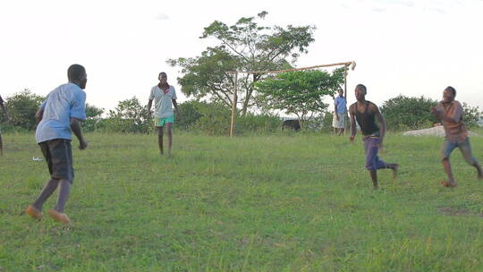 在草地上踢足球的孩童