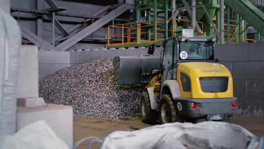 装载机或反铲挖土机将一堆废物运送到废物回