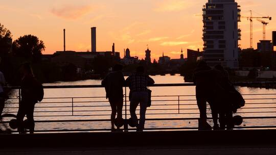 欣赏河流日落景观的游客剪影