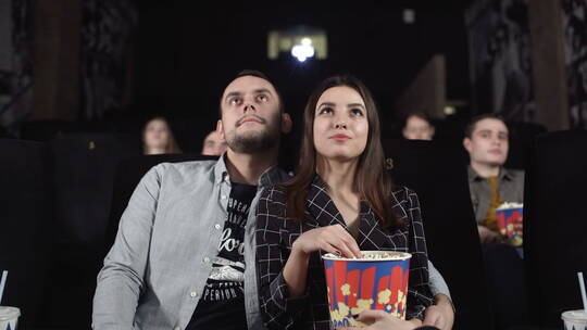 情侣在电影院看电影吃爆米花视频素材模板下载