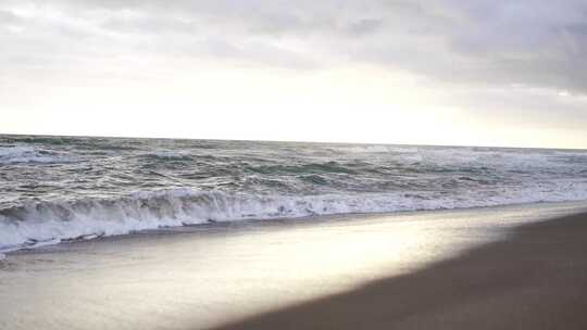日落下海浪拍打沙滩