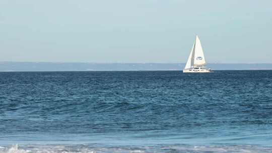 双体船出海，一些海浪拍打着卡斯卡伊斯的海滩