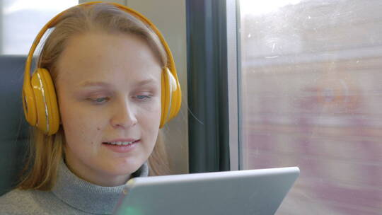 女人戴着耳机在火车上听歌