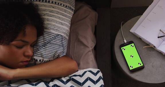 睡醒的女人起来点了一下绿屏智能手机