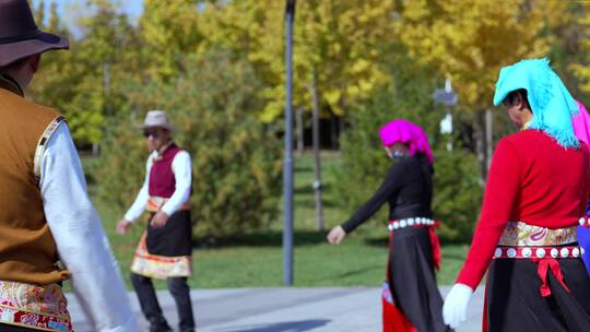 秋天围成圈穿藏族民族服饰跳舞的老年人